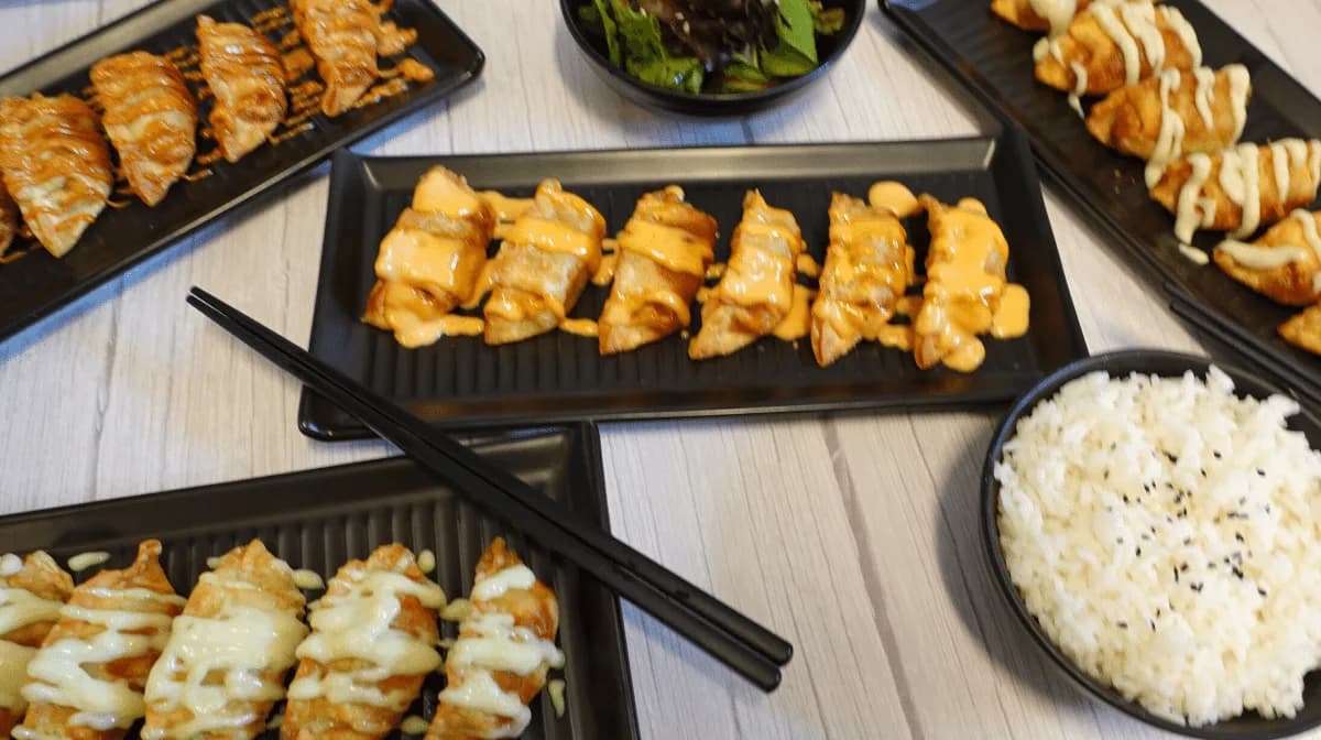 A spread of Bunch of Dumplings: crispy dumplings with aioli drizzles and steamed rice
